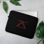 A sleek black laptop sleeve featuring the zSecurity logo in red, shown on a table with leaves as decor, designed to protect laptops in style.